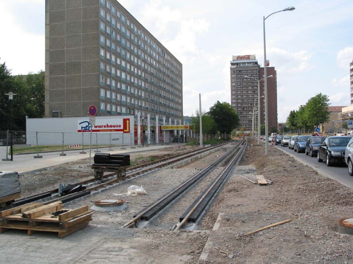 Baustelle einer Straßenbahnschiene mit Hochhäusern im Hintergrund