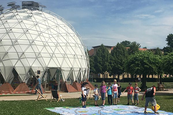 Kuppelzelt in Stadtpark (Klimapavillon) mit Kindern in Aktion davor