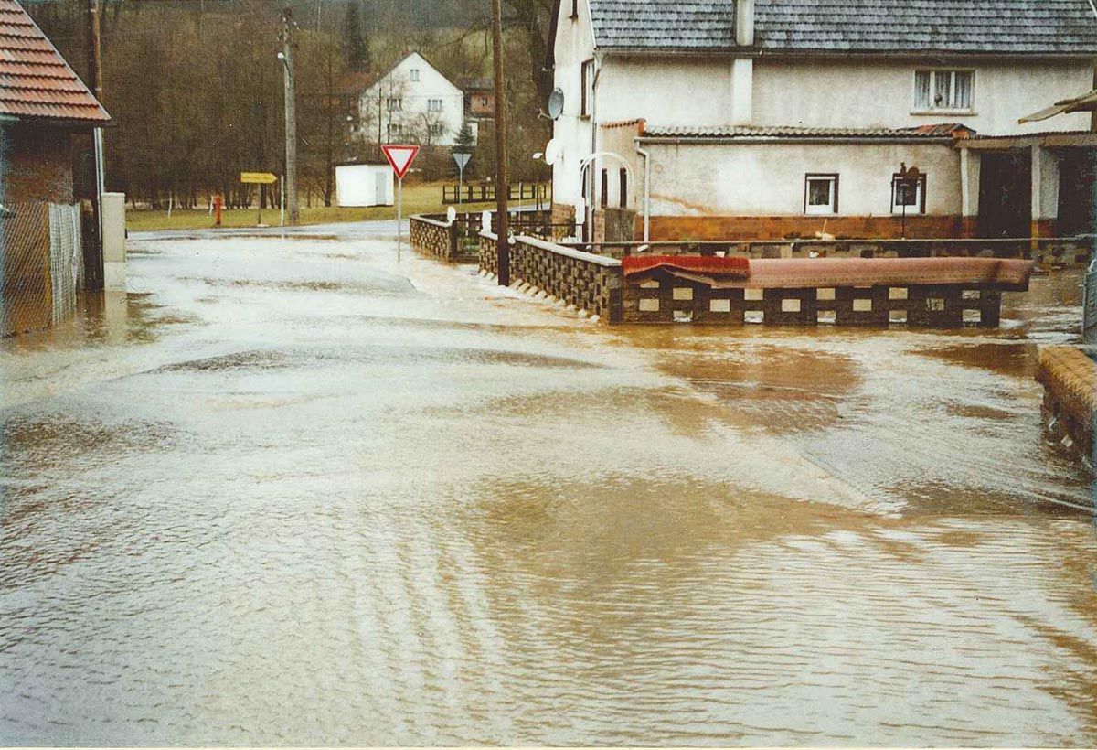 überschwemmte Dorfstraße und Höfe